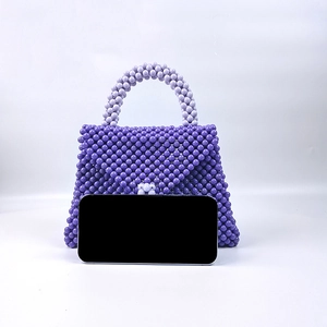 Dettaglio della borsa a mano viola con perline fatta a mano e confronto dimensioni smartphone