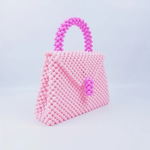 Dettaglio della borsa di perline fatta a mano con trama rosa e design della patta intrecciata