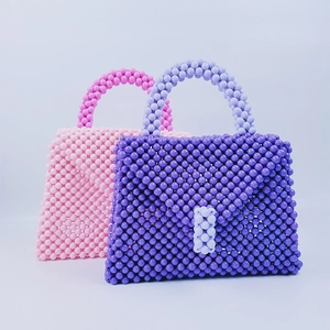 Dettaglio di borse fatte a mano in perline viola pastello e rosa con coperture intrecciate