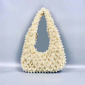 Detail of beaded underarm bag featuring faux pearls and intricate woven lattice pattern