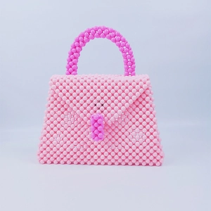 Dettaglio della texture della borsa fatta a mano in perline rosa con patta colorata