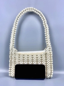Sac à main fait main en perles tissées avec poignée sur fond bleu dégradé