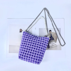 Detail of hand-beaded checkered pattern on mini pearl shoulder bag with silver chain