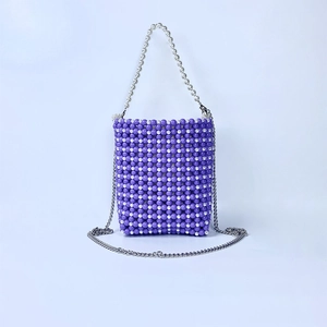 Macro detail of purple and white beaded woven bag with premium pearl handle and silver chain