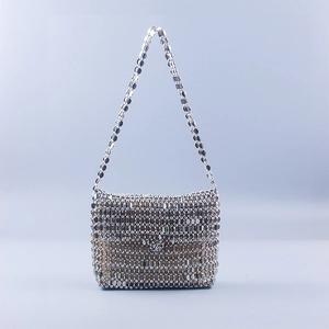 Close-up of hand-woven silver metal sequins on a futuristic evening shoulder bag