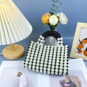 Detail of handcrafted black and white beaded handbag with contrast pearl stripe pattern