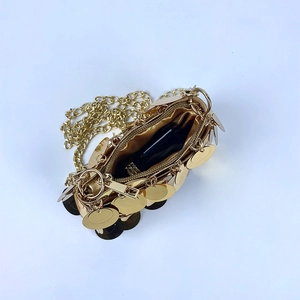 Detail of gold sequin mini bag showing luxury interior lining and metal chain strap