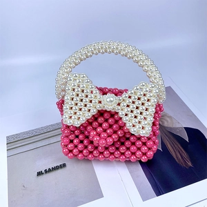 Detail van roze kralentas met grote witte strik geplaatst op een modetijdschrift