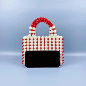 Detailed view of handmade beaded purse with red polka dots and smartphone for size scale