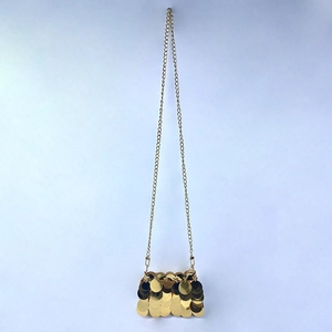 Detailed view of shimmering gold sequin handbag with elegant metallic chain strap