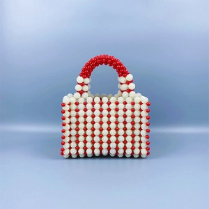 Detail of handmade beaded handbag with red and white resin pearls in retro style