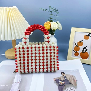 Detail of red and white handmade beaded handbag featuring high-gloss faux pearls