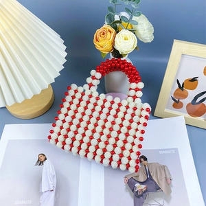 Detail of handmade red and white pearl beaded handbag with woven round handle