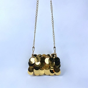 Detail of gold sequin mini bag with layered round metallic discs and fine chain strap