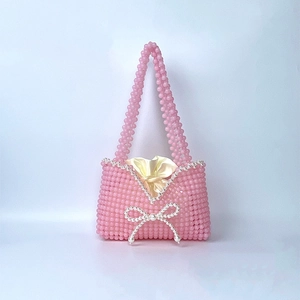 Detail of handmade beaded handbag with pink beads, white pearls, and a yellow satin liner