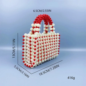 Detail view of handmade pearl handbag with red beaded handle and dimensions annotation