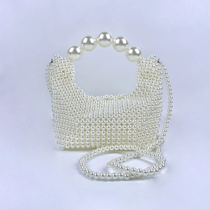 Detailopname van handgeweven parel-avondtas met groot parelhandvat en elegante riem