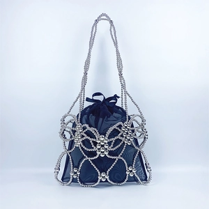 Detail of silver beaded handbag with woven butterfly pattern and black mesh drawstring liner