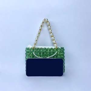 Vue détaillée du sac en perles vertes avec anse en perles et comparaison de taille mobile