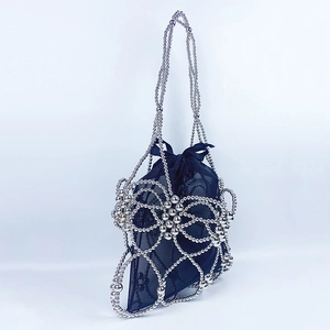 Detail of silver beaded handbag showing intricate petal weave and black mesh drawstring liner