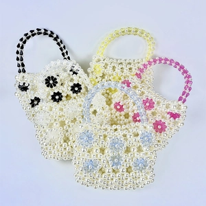 Detail of four handmade beaded mini bags with colorful acrylic fairy flower patterns