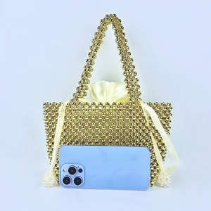 Detail of handmade gold beaded tote bag with satin drawstring liner and ribbon bow