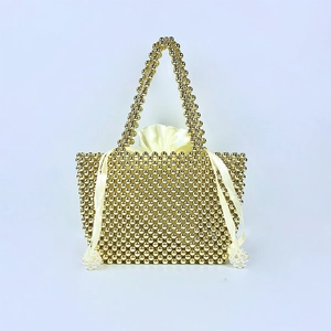 Detail of luxury gold beaded handbag featuring white silk drawstring liner and pearls