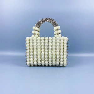 Detail of handmade beaded handbag with white pearls and silver metal texture beads