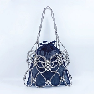 Detailed view of silver metal bead woven outer frame with navy mesh drawstring inner bag