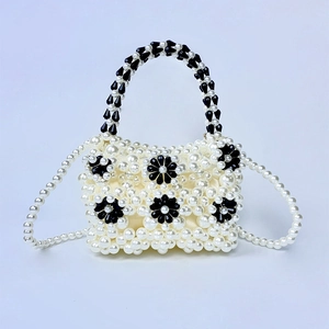 Detail of beaded mini bag showing white pearls and black acrylic flowers texture