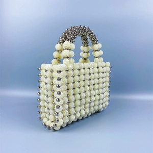 Detailed view of handmade beaded handbag with cream pearls and silver metal accents