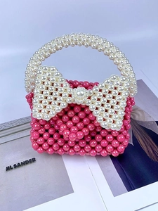Handgemaakte roze parel handtas met een grote witte strik op een modetijdschrift achtergrond