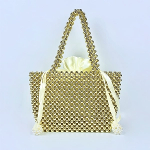 Detail of handmade gold beaded handbag with silk drawstring lining and pearl tassels