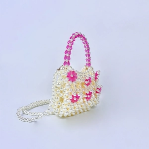 Detail view of handmade beaded pearl handbag with pink floral acrylic flower accents