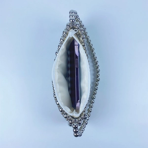 Detailed interior view of silver beaded bag showing capacity for a large smartphone