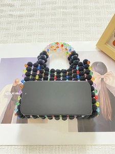 Macro detail of a handmade beaded mini bag with colorful beads and smartphone for size scale