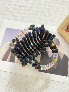 Detailed top view of a handmade beaded handbag with colorful accents on a magazine