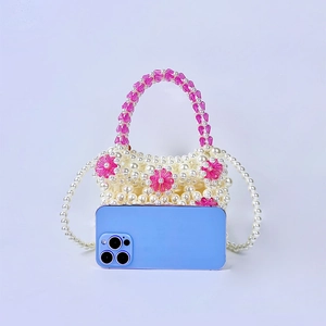 Detail of beaded mini bag with floral accents and long faux pearl shoulder strap