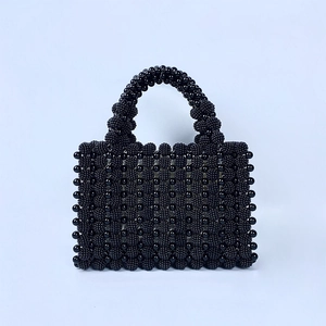 Détails d'un sac de soirée fait main en perles noires avec des motifs texturés