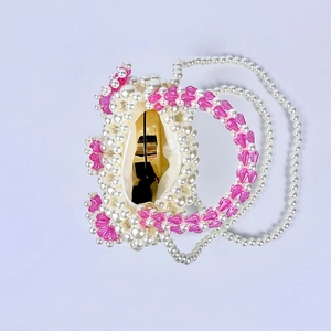 Detailed view of handmade beaded mini bag with white pearls and pink crystal flowers