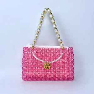 Détail du sac à main en perles de cristal rose avec poignée en perles et fleur