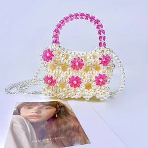 Detail of beaded handbag with pink acrylic flowers, faux pearls and crossbody chain
