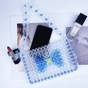 Detail of handmade beaded bag with blue bow pattern and space for essentials