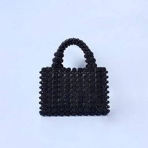 Gros plan d'un sac cabas en perles noires fait main avec tissage de perles texturées