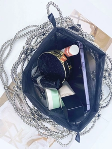 Silver beaded woven handbag with black mesh interior showing spacious storage for essentials