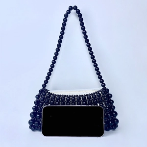 Detail of black handcrafted beaded shoulder bag showing weaving and interior lining