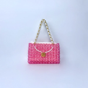 Détail du mini sac à main en perles roses avec anse en perles et décor floral