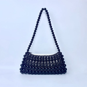 Detailed shot of handmade black beaded handbag with white fabric lining and pearl chain