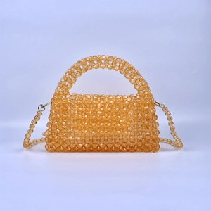 Amber orange beaded crossbody bag made of woven acrylic pearls with a top handle