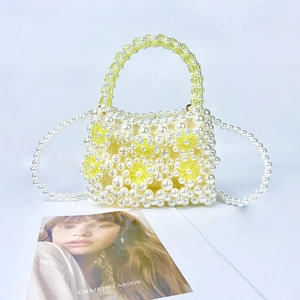 Detail of beaded pearl handbag with yellow acrylic flowers and long shoulder strap